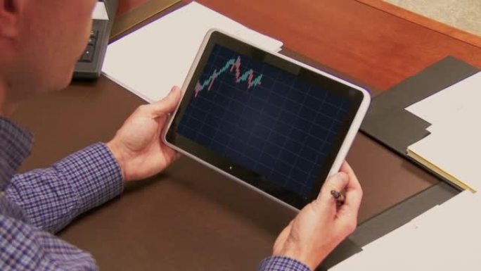 男子在平板电脑上检查股票市场