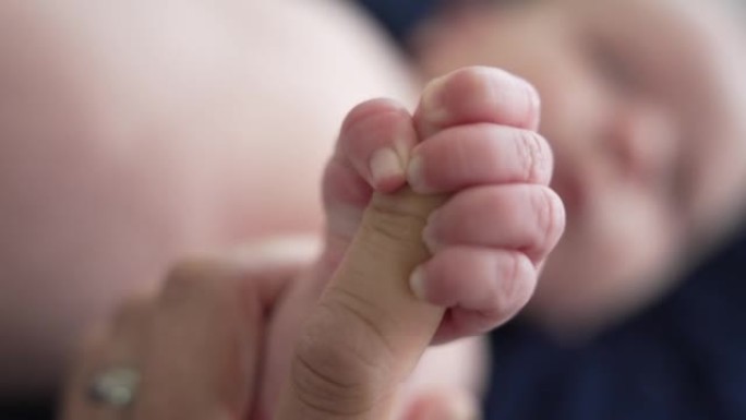 新生婴儿男婴的手抓住爸爸的手指
