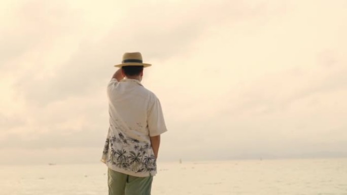 夏季日落时在热带海滩上行走的亚洲男子的4k肖像