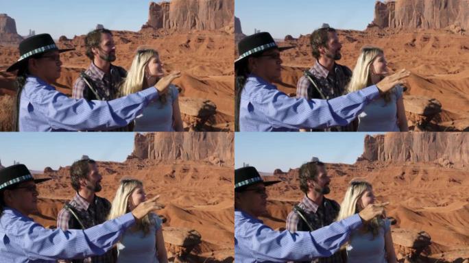 活跃的年轻夫妇在亚利桑那州纪念碑谷纳瓦霍部落公园与土著纳瓦霍人向导一起游览