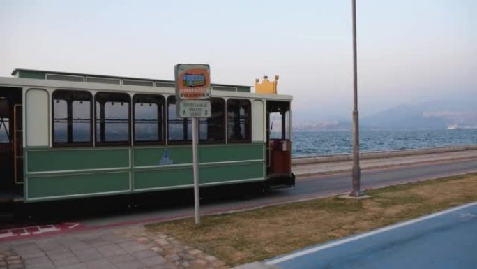观光复古电车傍晚沿大城市海滨经过