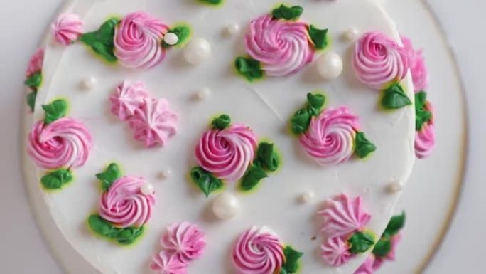 旋转白色奶油和粉红玫瑰蛋糕，顶视图，特写