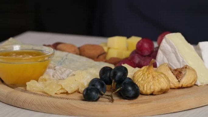 奶酪盘配卡门培尔布里帕尔马干酪荷兰奶酪。西班牙或意大利开胃小吃，奶酪，坚果，面包，葡萄，枣，无花果。