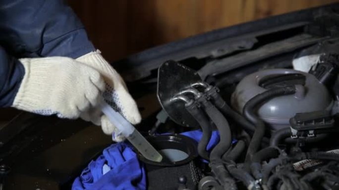 汽车机械师从燃油滤清器下方清除旧的燃油残留物。汽车燃油系统的维护。特写