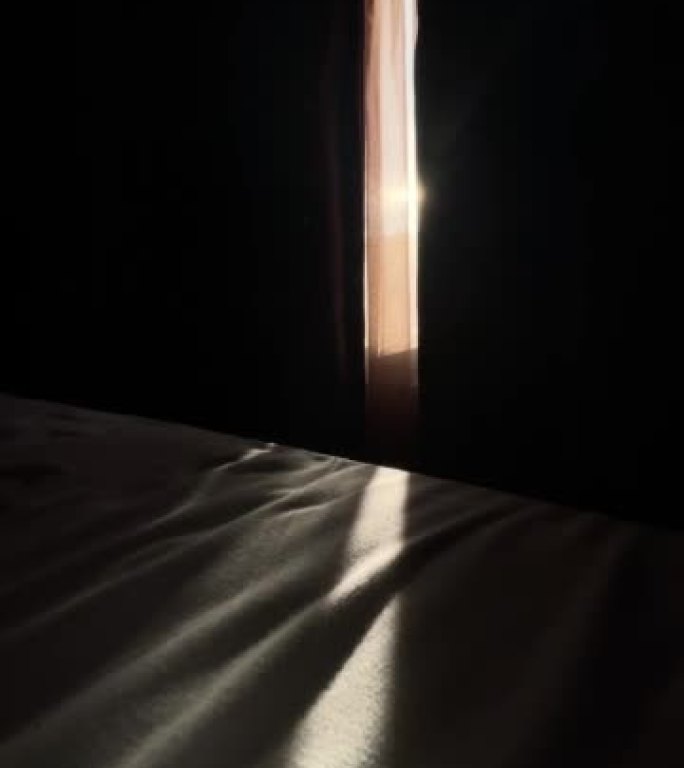 早晨的阳光穿过窗帘进入房间，躺在床上
