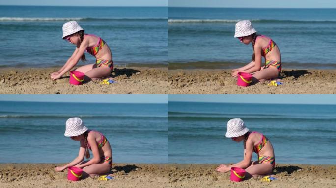 可爱的小女孩在海滩上玩沙子。童年和暑假