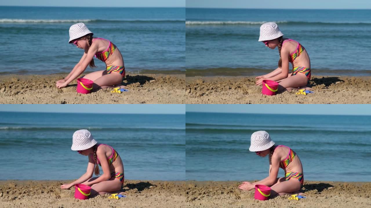 可爱的小女孩在海滩上玩沙子。童年和暑假