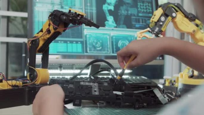 教育主题: 女孩学习如何在数字平板电脑上控制玩具机器人手臂，科学工程，教育，技术