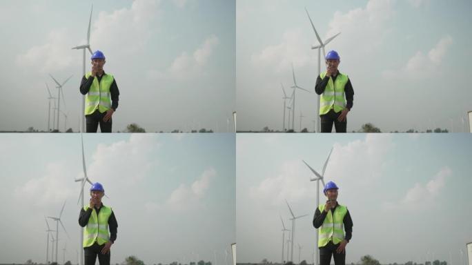 Blue collar worker at electricity site. Windmill f