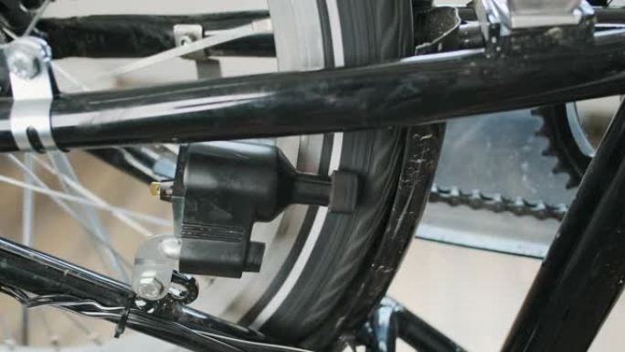 自行车发电机，车轮和踏板旋转，特写。一种老式的自行车发电机，可以在轮胎周围旋转电。