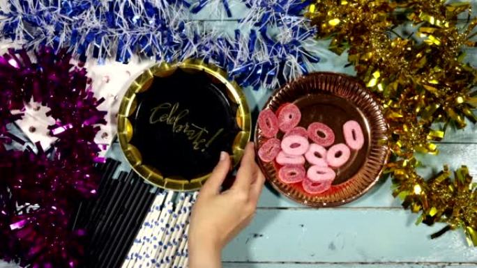 生日派对概念: 彩色金属丝，配有一次性杯子和盘子、木桌上的吸管和糖果果冻