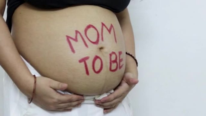 年轻的孕妇从不同的角度展示着她圆滚滚的肚子和妈妈的信息