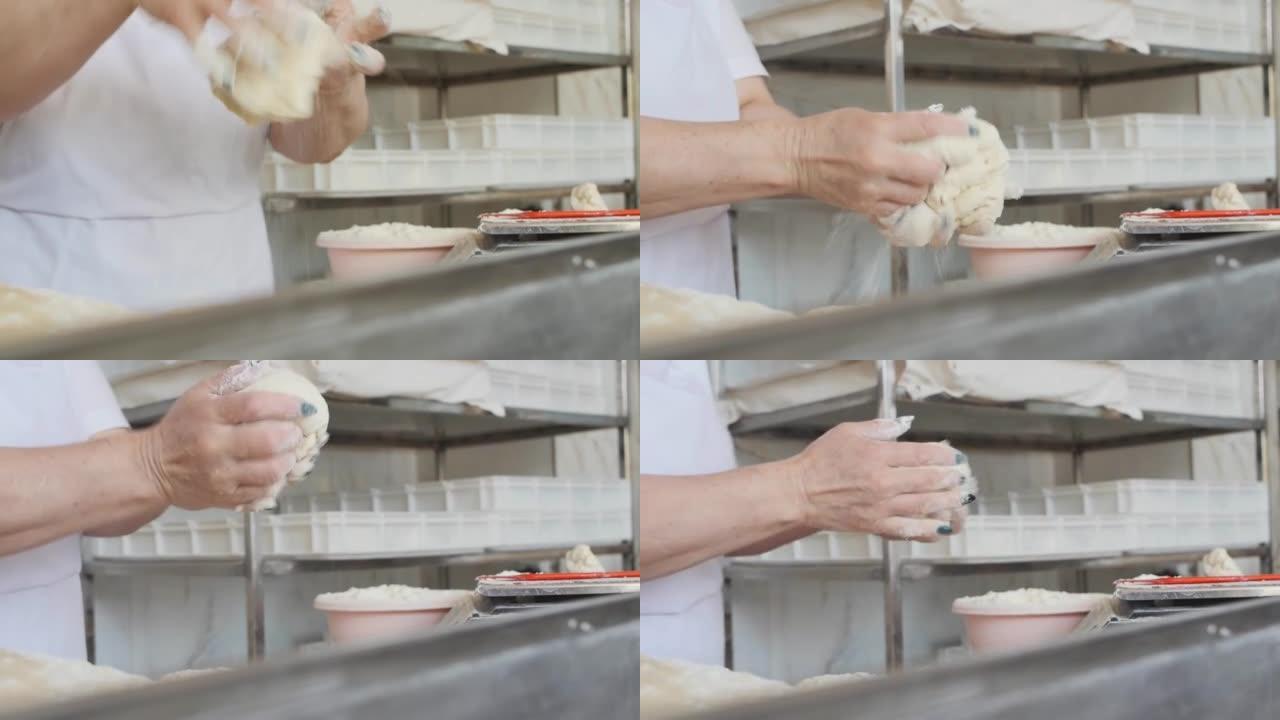 面包师的雌性手从面团中形成一个圆面包，用于在烤箱中烘烤。面包烘焙过程