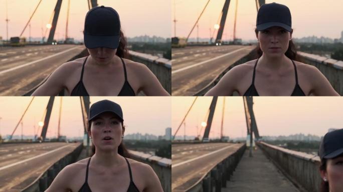 年轻上进的女孩正准备在日落时在城市桥上奔跑。健康的生活方式，运动理念