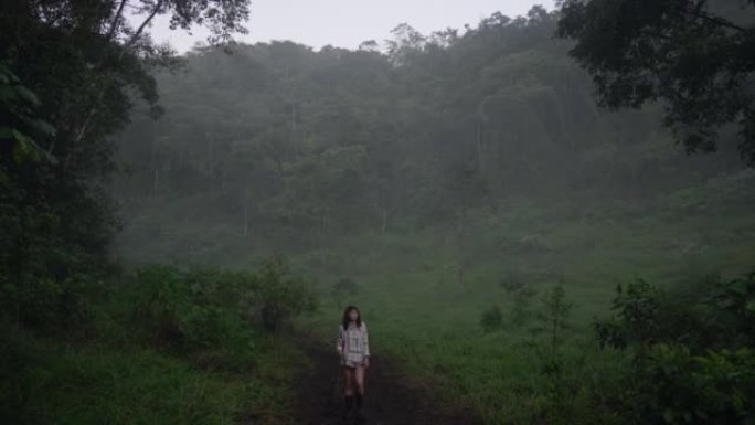女人在雾中的丛林中徒步旅行