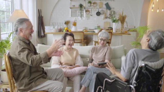 团体亚洲老年人朋友一起坐在家里的客厅里，一起享受聊天。