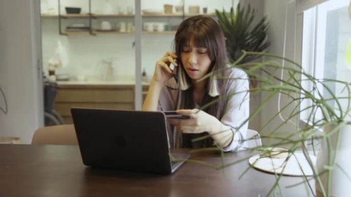 年轻的亚洲女子电话联系银行呼叫中心关于信用卡被盗