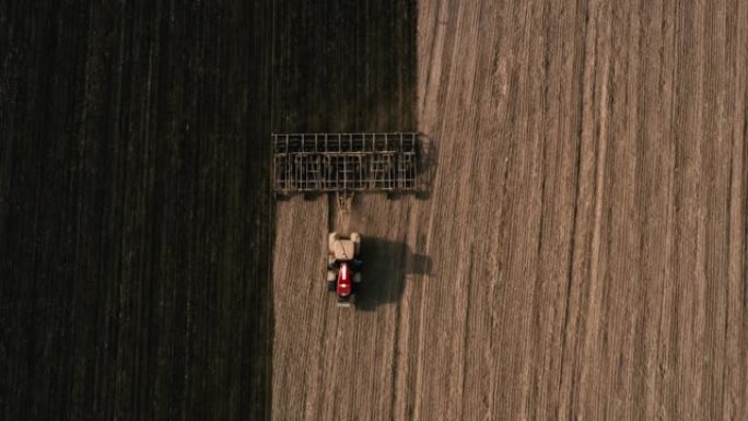 农民在拖拉机上，用播种机械在田间播种小麦或玉米。农艺农场的工作概念，以生产有机食品并从中获利