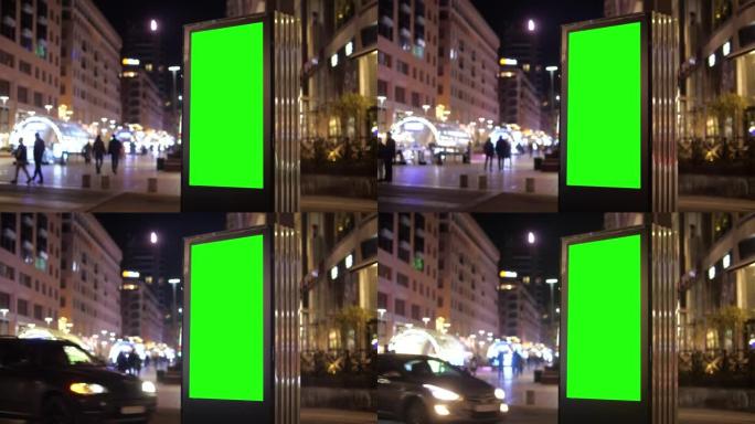 夜间城市交通背景上带有绿色屏幕的广告牌