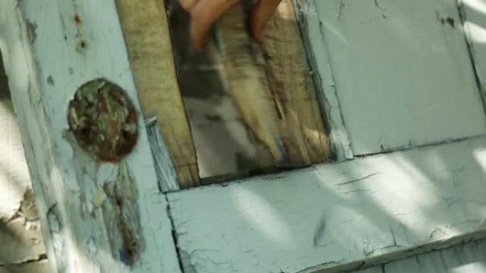 男人使用撬棍并折断，从木门上取下旧的插锁
