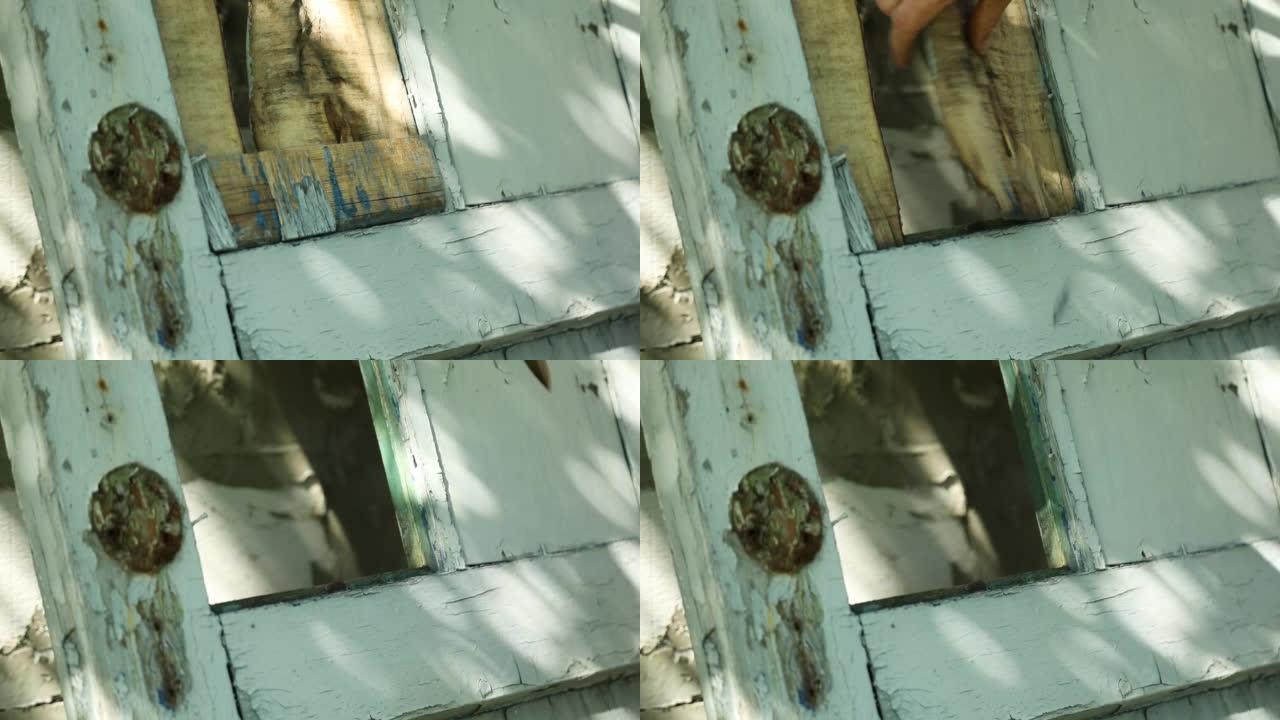 男人使用撬棍并折断，从木门上取下旧的插锁