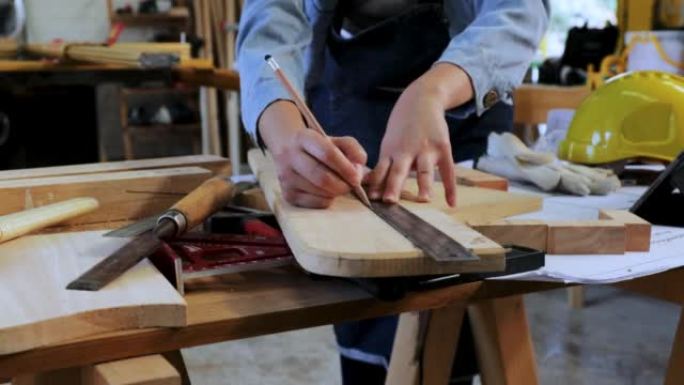 近景:木匠在工坊工厂制作工艺品的木头上画线