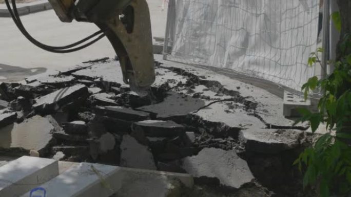 挖掘机用水锤钻打破街道的沥青