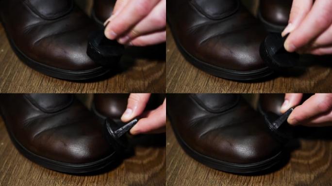 鞋匠恢复真皮男鞋，在旧破旧的鞋子上涂上棕色奶油，特写，鞋匠擦鞋