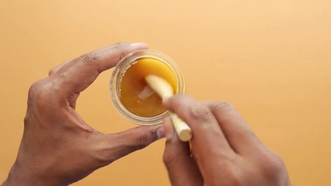 用勺子在桌子上的容器中挑选自制的酥油，