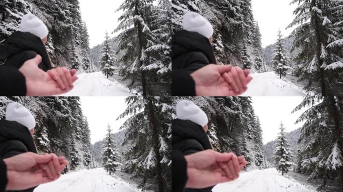 恋爱中的情侣走在冬天的路上，他们牵着手，一个美丽的冰雪覆盖的森林