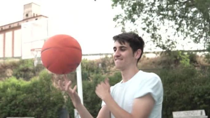 年轻的篮球运动员男孩用一根手指滚动球。