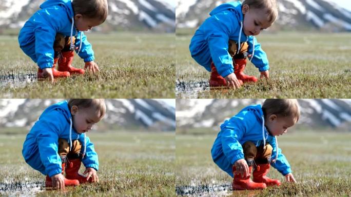 在草地上玩泥水的可爱男孩