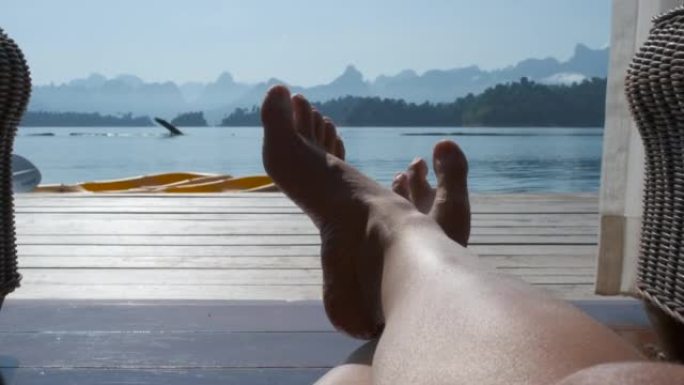 躺在度假露台上的人们的视点可以看到外面的湖景。短裤
