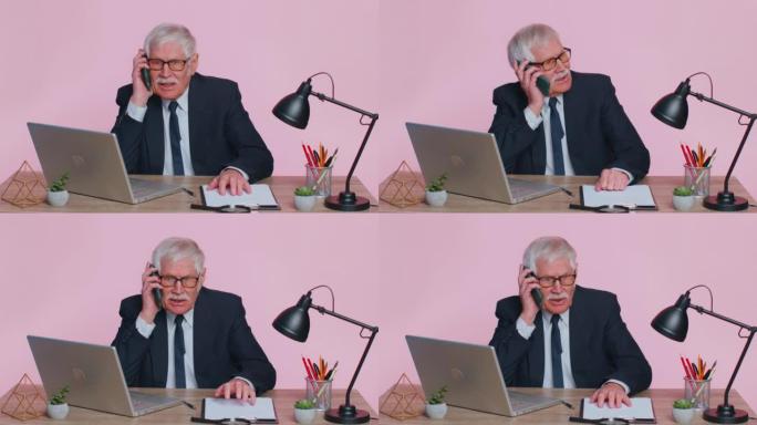 愤怒的高级商人在粉红色办公室打电话工作惹恼老板说手机吵架