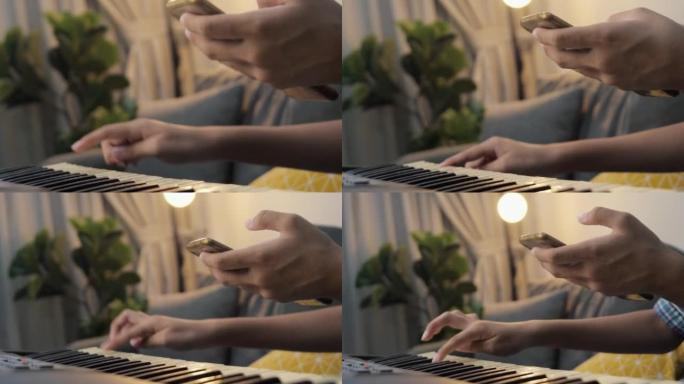 女孩在家里的夜晚通过沙发上的移动应用学习弹奏键盘乐器，生活方式概念。身体部位。