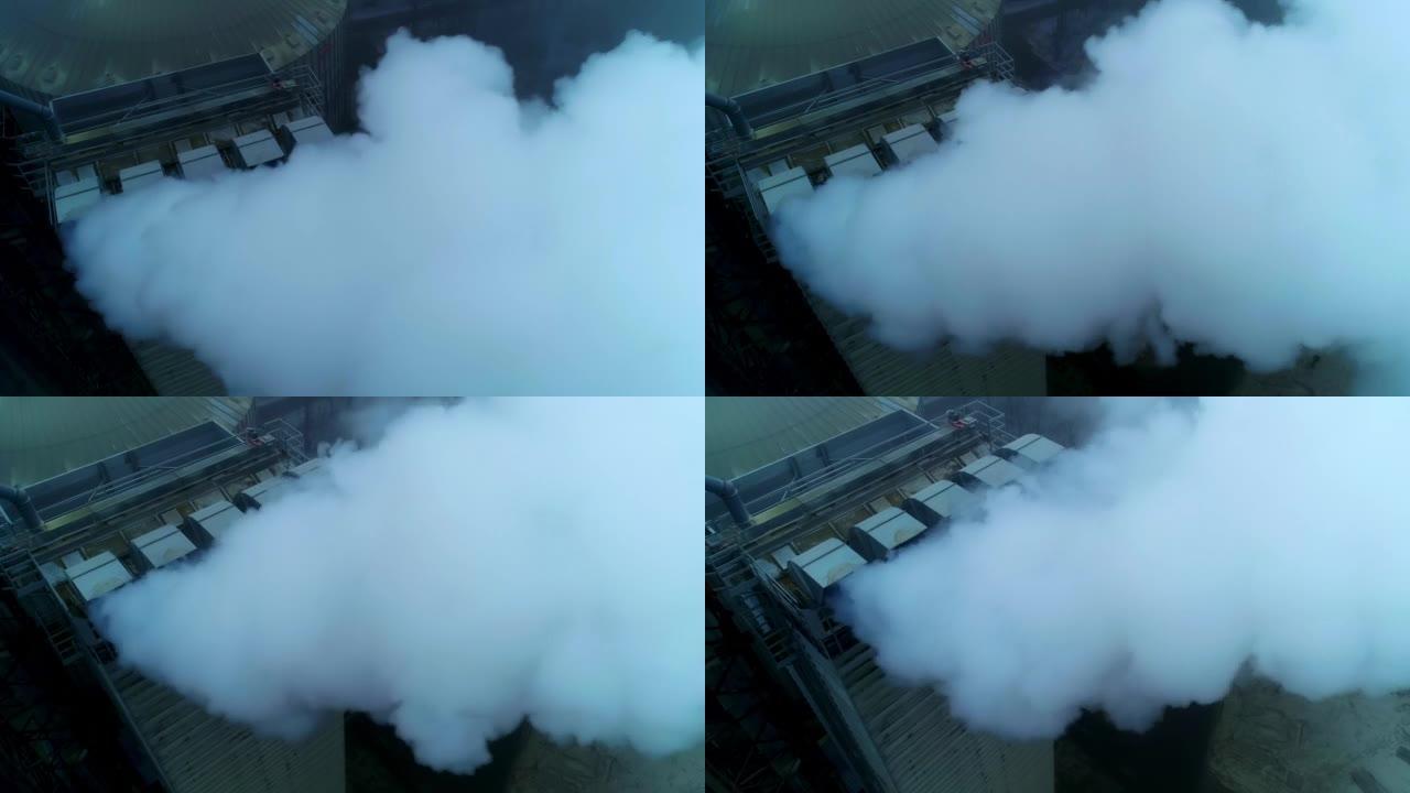 电梯厂房的工作场所，粗大的管道冒着浓烟。在灰色的天气背景下，在粮仓仓顶上空飞行。