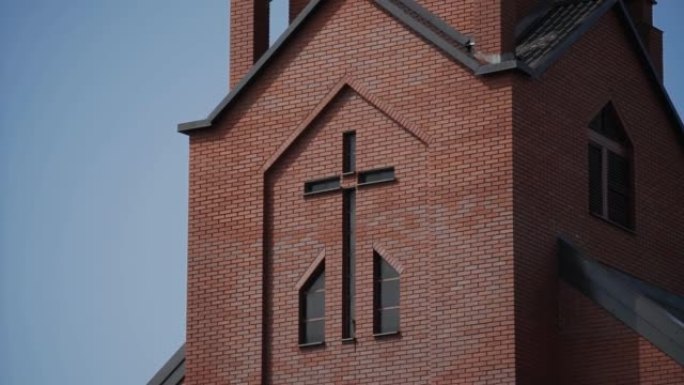 特写，现代红砖教堂立面用小玻璃窗做的十字架