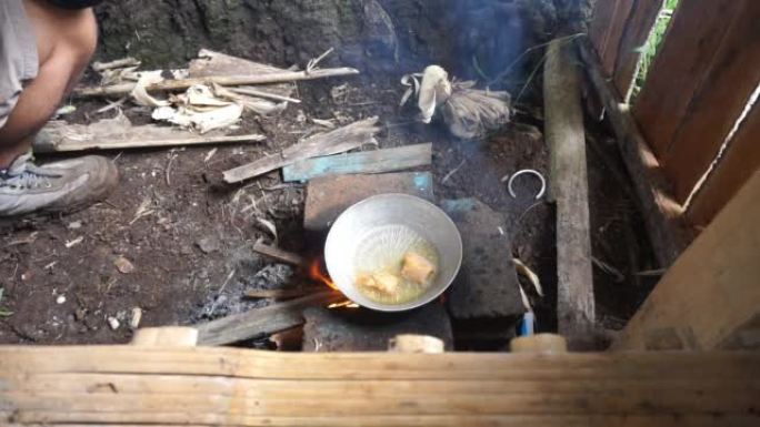 使用传统的燃木炉烹饪咸鱼