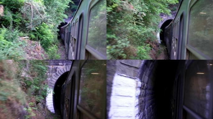 火车进入绿色森林中的山区老式铁路轨道上的隧道