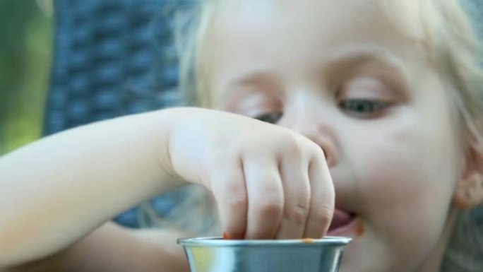 Little girl dips french fries in ketchup and eats 