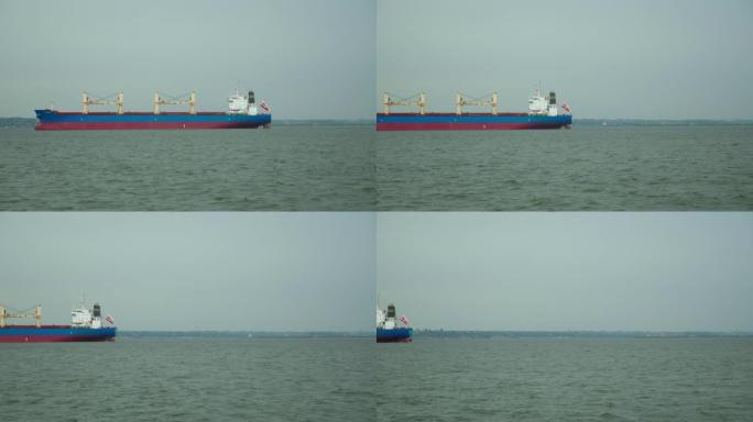 红色货运谷物船的延时漂浮在平静的海面上。以廉价方式交付大件货物的概念。海上运送谷物