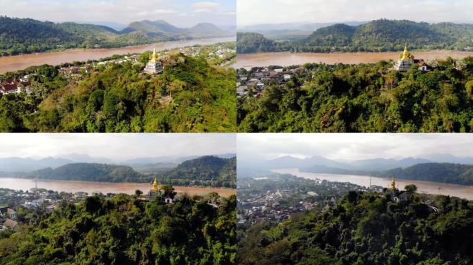 琅勃拉邦老挝全景。富西山顶，主宰城市的小山，日出日落景色的热门地点。富斯山顶上的金色佛塔。移动无人机