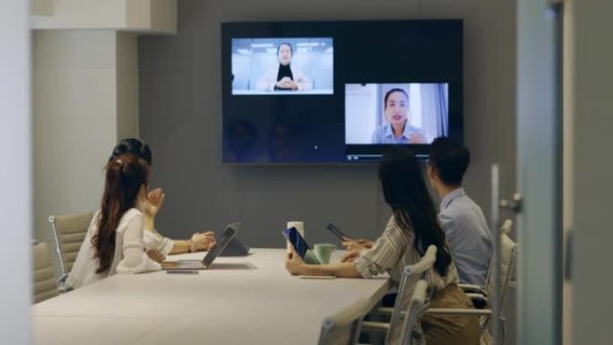 亚洲商人正在使用多媒体在会议室开会。