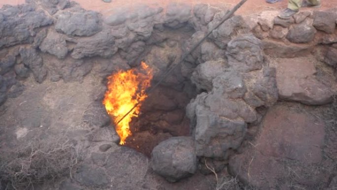 来自加那利群岛Timanfaya国家公园火山口的火焰。西班牙兰萨罗特岛的地热导致干草燃烧。地热能示范