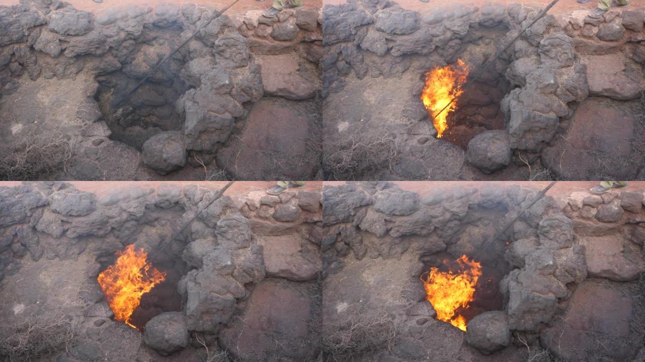 来自加那利群岛Timanfaya国家公园火山口的火焰。西班牙兰萨罗特岛的地热导致干草燃烧。地热能示范