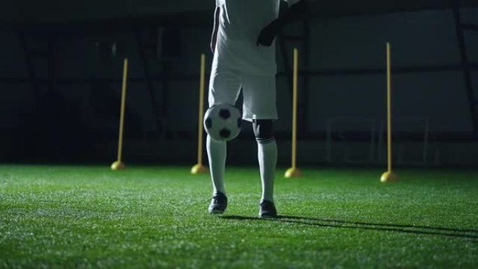 黑人足球运动员用脚踢球，在体育馆训练，运动员腿部特写镜头
