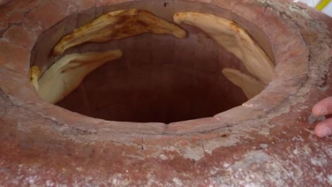 面包师在坦多 (tandoor)，粘土烤箱中制作土耳其lavash。烘焙过程。