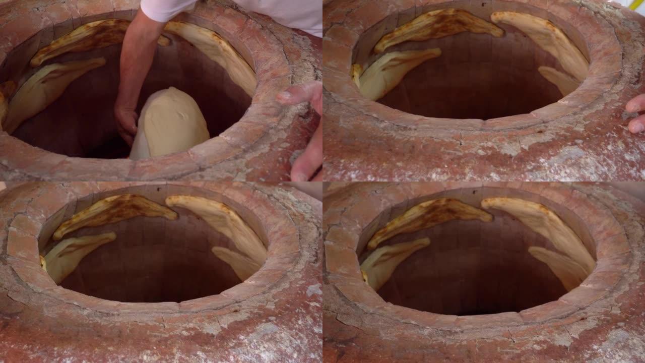 面包师在坦多 (tandoor)，粘土烤箱中制作土耳其lavash。烘焙过程。