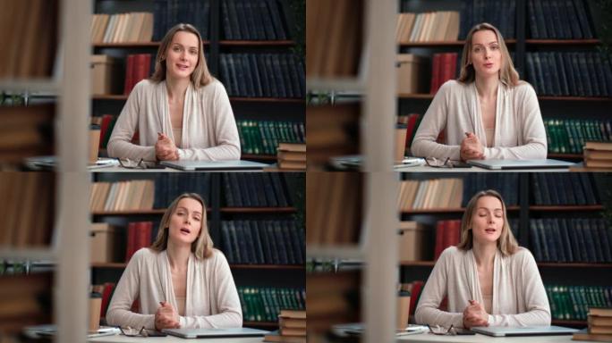 肖像友好的女性文学商业博主谈论拍摄视频在图书馆工作