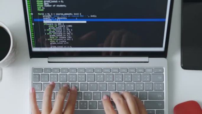 开发人员程序员在笔记本电脑上工作，键入键盘，以检查错误系统中的编码。顶视图